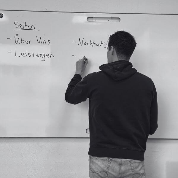 Ingo Bartels steht am Whiteboard und schreibt